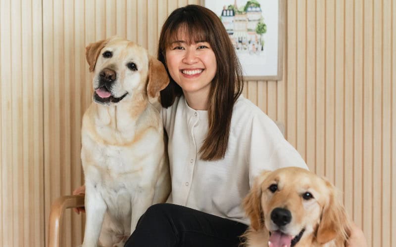 Kathy and her two dogs smiling at the camera.